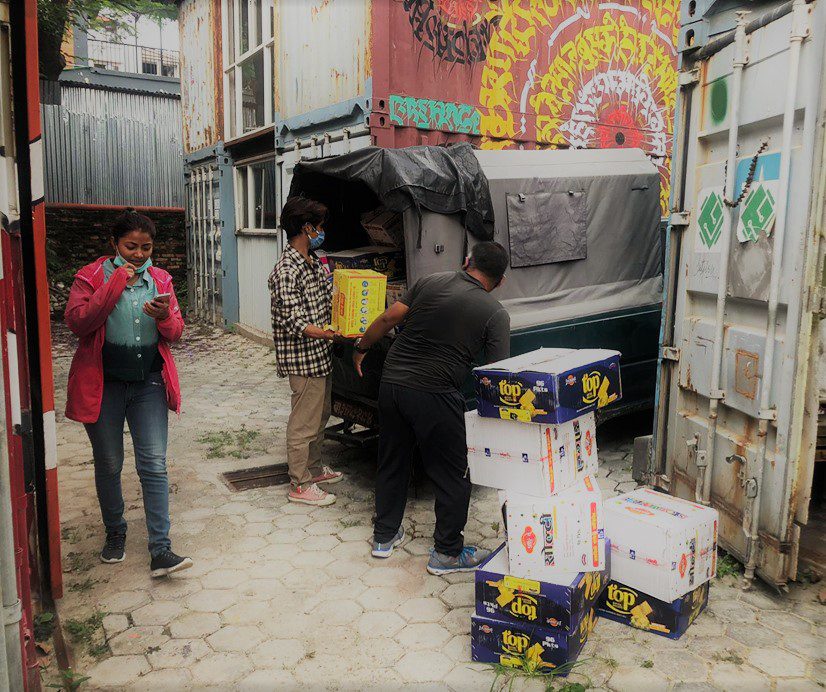 BlinkNow team unloading relief packages at Nepal Communitere for storage